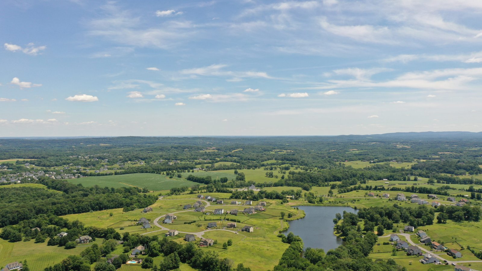 Aerial,View,Of,Mountains,And,Rural,Land,With,Country,Homes
